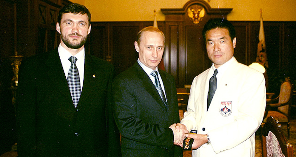 А. Ипатов (слева) на церемонии вручения черного пояса В. В. Путину
